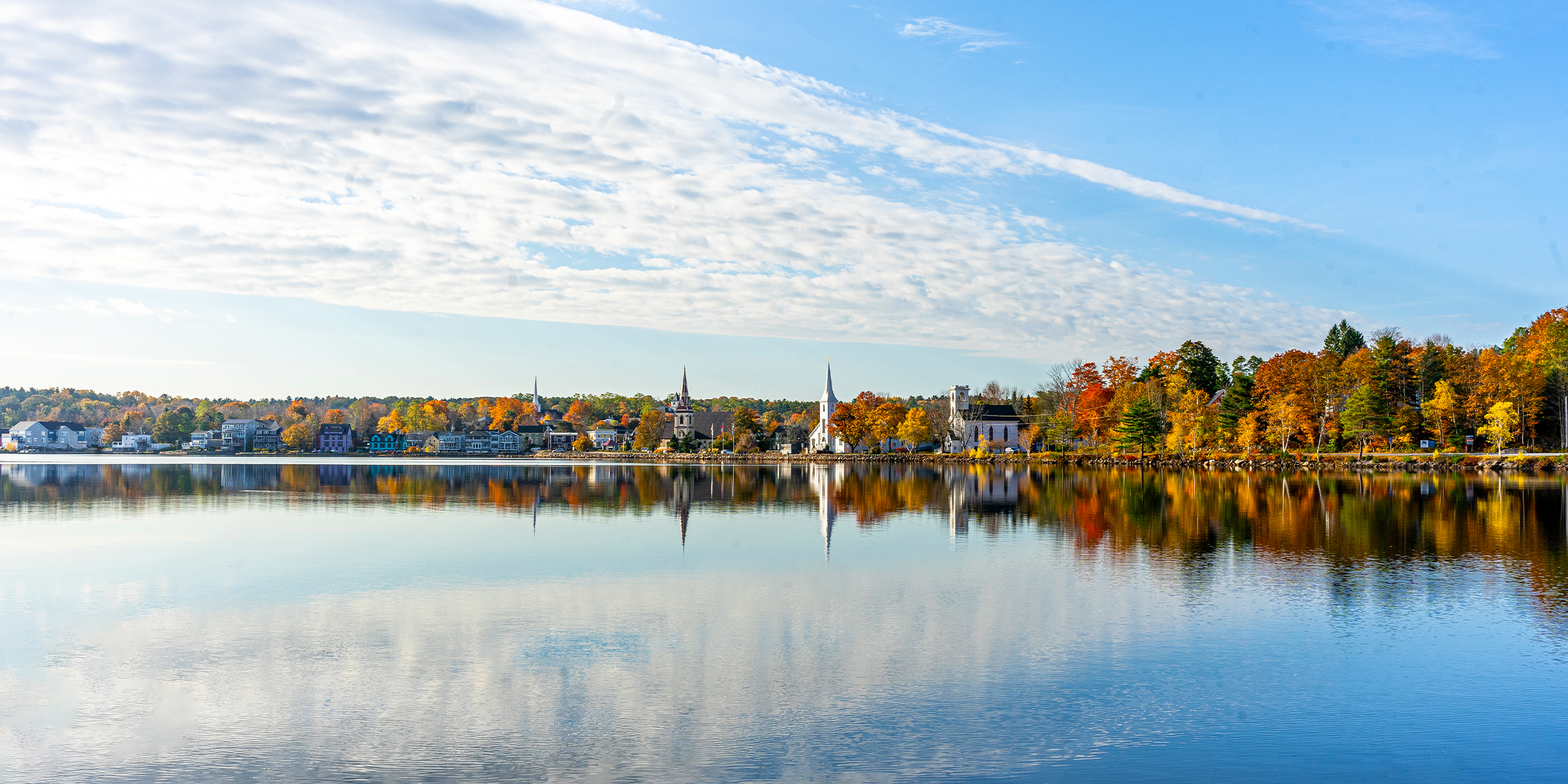 The Three Churches of Mahone Bay reflected in the harbour at golden hour